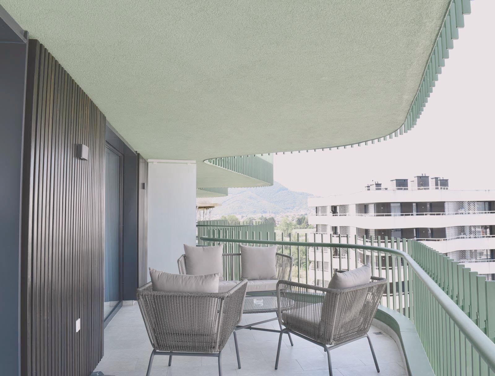 Covered balcony with wicker armchairs and mountain view